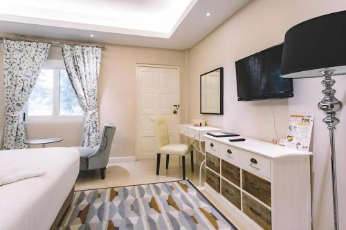 ein Schlafzimmer mit einem Bett, einem Schreibtisch und einem Fernseher in der Unterkunft Verona Boutique Hotel - The Verona Co., Ltd in Ban Wang Khon Daeng