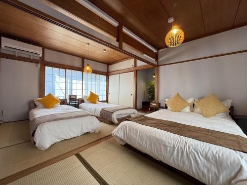 a bedroom with three beds in a room at 5 min Walk Noborito 16 mins Shinjuku,3 BR, 2 Bath in Kawasaki