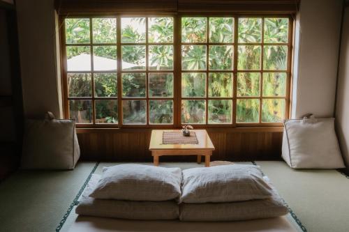 ein Zimmer mit einem Bett und einem Tisch vor einem Fenster in der Unterkunft 月光寶盒旅店 Moonlight Hostel in Kaohsiung