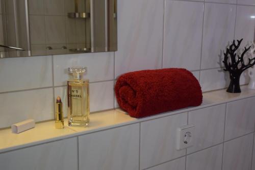 a bathroom counter with a red towel and a bottle of perfume at Ferienapartments Urlaub und Meer in Kühlungsborn