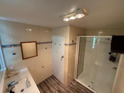 een badkamer met een douche en een wastafel bij Sunset View House in Warburton