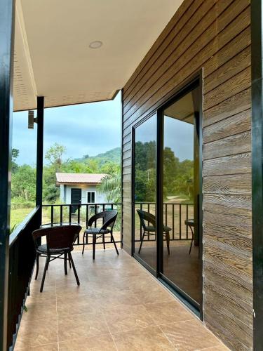 a patio with chairs and tables and glass doors at Serenia Garden Resort in Ko Lanta Yai
