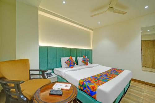 a bedroom with a bed and a table and a chair at FabHotel Morya Regency - Bhopal railway station platform no 6 in Bhopal