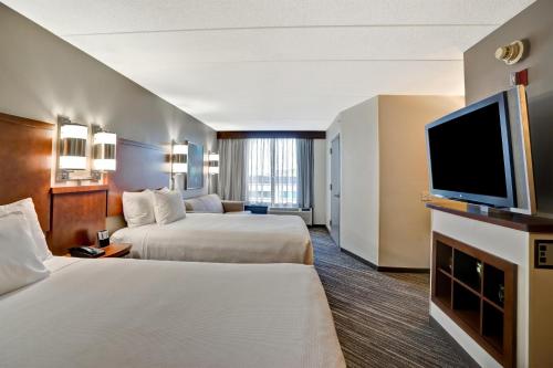 a hotel room with two beds and a flat screen tv at Hyatt Place Baltimore/BWI Airport in Linthicum Heights