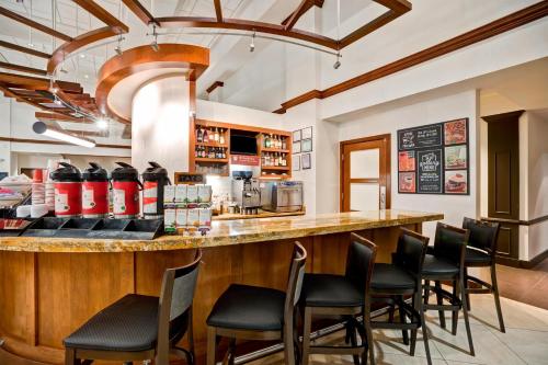 a bar with black chairs at a restaurant at Hyatt Place Baltimore/BWI Airport in Linthicum Heights