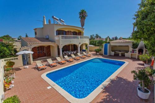 a house with a swimming pool in front of it at Villa Isabel by Villa Plus in Carvoeiro