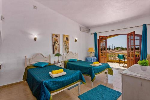 a bedroom with two beds and a balcony at Villa Isabel by Villa Plus in Carvoeiro