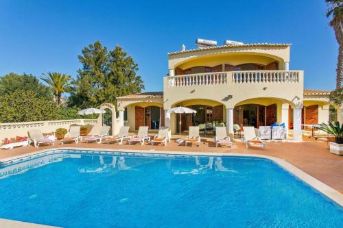 a villa with a swimming pool in front of a house at Villa Isabel by Villa Plus in Carvoeiro