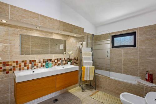 a bathroom with a sink and a tub at Villa Isabel by Villa Plus in Carvoeiro