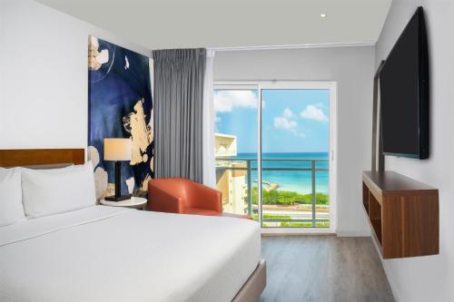 une chambre avec un lit et une vue sur l'océan dans l'établissement Embassy Suites By Hilton Aruba Beach Resort, à Palm-Eagle Beach