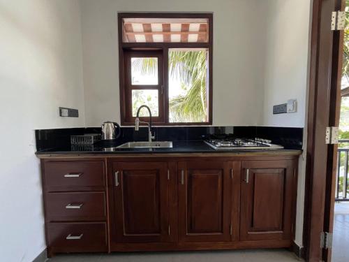 a kitchen with a sink and a window at Kiyoko Villa in Maha Induruwa