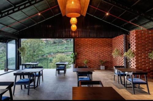 a restaurant with tables and chairs and a brick wall at Penthouse Bandarawela in Bandarawela