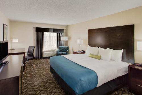 a hotel room with a large bed and a television at La Quinta by Wyndham Springfield in Springfield