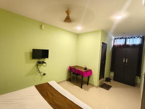 a room with a table and a tv on the wall at THE METRO INTERNATIONAL HOTEL in Hyderabad