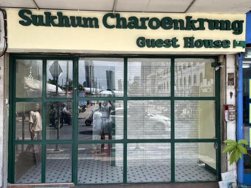 a front door of a guest house with people walking outside at Sukhum Charoen Krung Tak-Sin bridge guest house in Bangkok