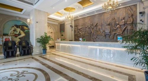 a lobby of a hotel with a painting on the wall at Vienna International Shanghai Nanxiang in Chenjiahang