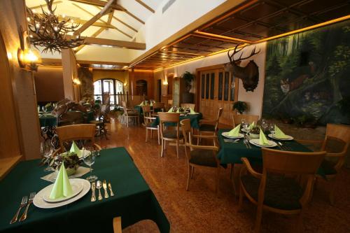 une salle à manger avec des tables et des chaises vertes dans l'établissement Lovecká Bašta, à Strakonice