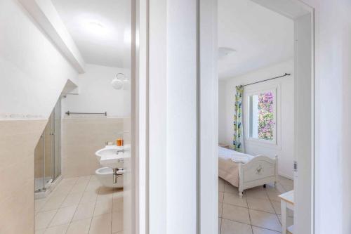 ein weißes Badezimmer mit Waschbecken und Toilette in der Unterkunft Holiday home in Baja Sardinia 30356 in Baja Sardinia