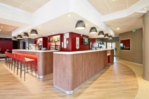 un bar dans un restaurant aux accents rouges dans l'établissement Campanile Villejuif, à Villejuif