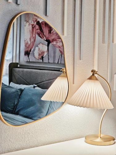a mirror on a wall with a bed and a lamp at Exquisite jazzy warm deco nearby the Strip - Top 15 Best Vegas Vacation Home recommended by Conde Nast Traveler in Las Vegas