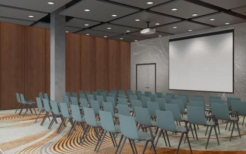 uma sala de conferências com cadeiras e um ecrã branco em Hyatt Place Tallinn em Taline