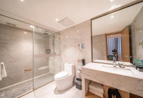 a bathroom with a sink and a toilet and a shower at World Hotel Jinan Harmony Plaza Qilu Children's Hospital Branch in Jinan