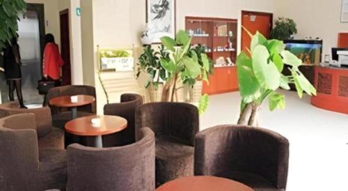 a room with some chairs and tables and plants at GreenTree Inn Jinan Bus Terminal in Jinan