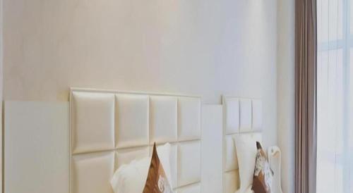 a mirror in a white room with pillows at Changshu Please Hotel in Changshu