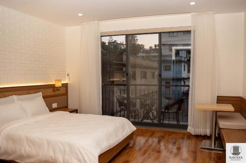 Un dormitorio con una cama y una ventana grande en Navaya Residence, en Pātan