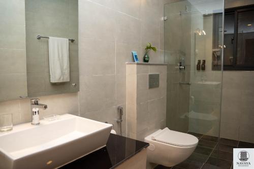 Un baño con lavabo, inodoro y ducha. en Navaya Residence, en Pātan