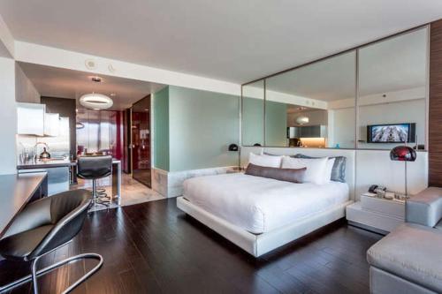 a bedroom with a large white bed and a kitchen at Palms place 51st floor & strip view in Las Vegas