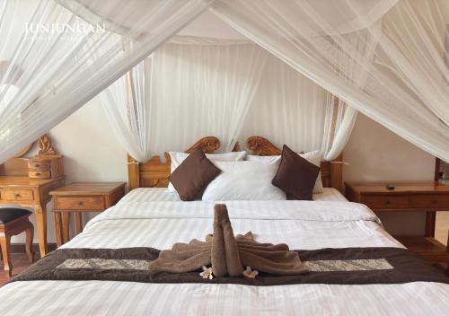 a bedroom with a white bed with a canopy at Serenity Villa & Spa in Ubud