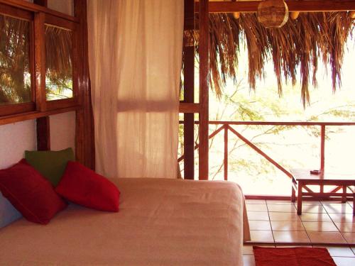 a bedroom with a bed and a large window at Muelle Viejo Bungalows in Los Órganos