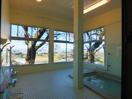 baño grande con árbol y bañera en 眺望の湯宿弁天, en Tonami