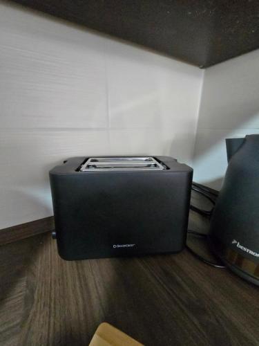 ein schwarzer Toaster, der auf dem Boden in einem Zimmer steht in der Unterkunft FERIENWOHNUNG 75m2 APARTMENT in ZITTAUER STADTZENTRUM INNENSTADT INNENRING TOP LAGE - WOHNEN AUF ZEIT IN ZITTAU - 3 RAUM WOHNUNG in Zittau