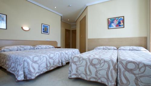 two beds in a hotel room with two bedsvisor at Hotel Mediodia in Madrid
