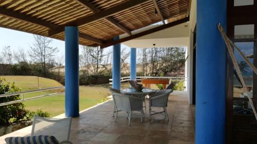 eine Terrasse mit einem Tisch und Stühlen unter einer Pergola in der Unterkunft Casa de Praia em Mundaú in Mundaú