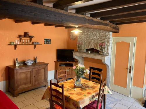a dining room with a table and a fireplace at Chez Manon in Grimault