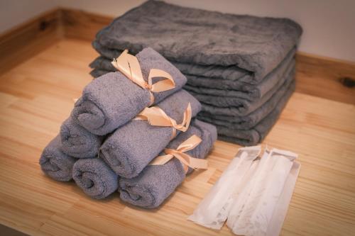 a pile of towels on the floor next to a bed at rinne 那須 Sauna Villa 2 in Nasu