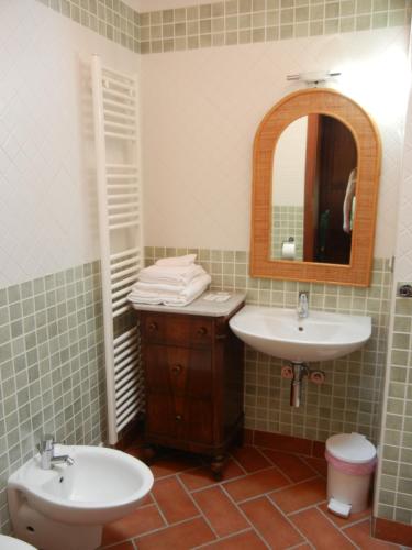 a bathroom with two sinks and a mirror and a toilet at La Colombarola in Farneto