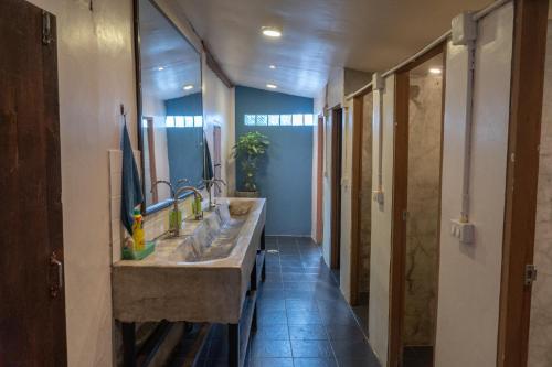 Un baño con dos lavabos y un espejo grande. en Easy house, en Pai