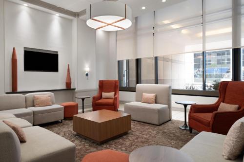 a lobby with a waiting room with chairs and a tv at Hilton Garden Inn Chicago Downtown/Magnificent Mile in Chicago