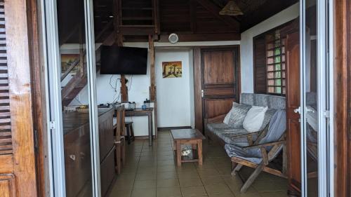 un soggiorno con un divano, un tavolo e una televisione di MADERA a Djamandjary