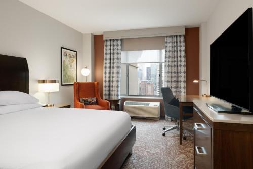 a hotel room with a bed and a desk and a television at Hilton Garden Inn Chicago Downtown/Magnificent Mile in Chicago