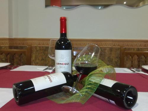 een fles wijn en een glas op een tafel bij Hostal la Campa in Chiclana de la Frontera