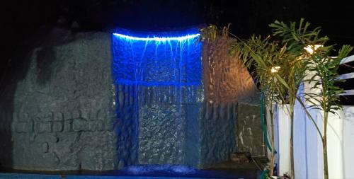 une fenêtre en verre bleu avec des lumières bleues dessus dans l'établissement It is Luxury villa with nature for relaxation, à Attappādi