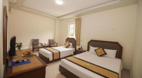 a hotel room with two beds and a television at Hai Long Hotel Cat Ba in Cat Ba