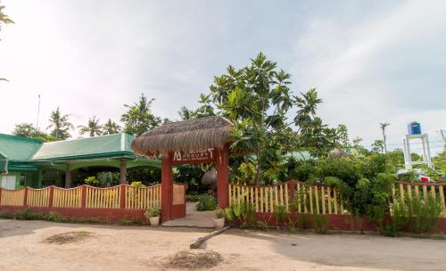 ein Restaurant mit einem Zaun vor einem Gebäude in der Unterkunft Moonlight Resort in Malapascua