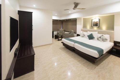 a hotel room with a bed and a television at Hotel Le Grande - Mumbai International Airport in Mumbai