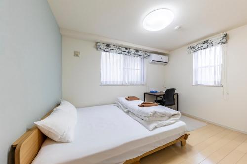 Postel nebo postele na pokoji v ubytování Jin's Place - 15m to Haneda & Shinagawa